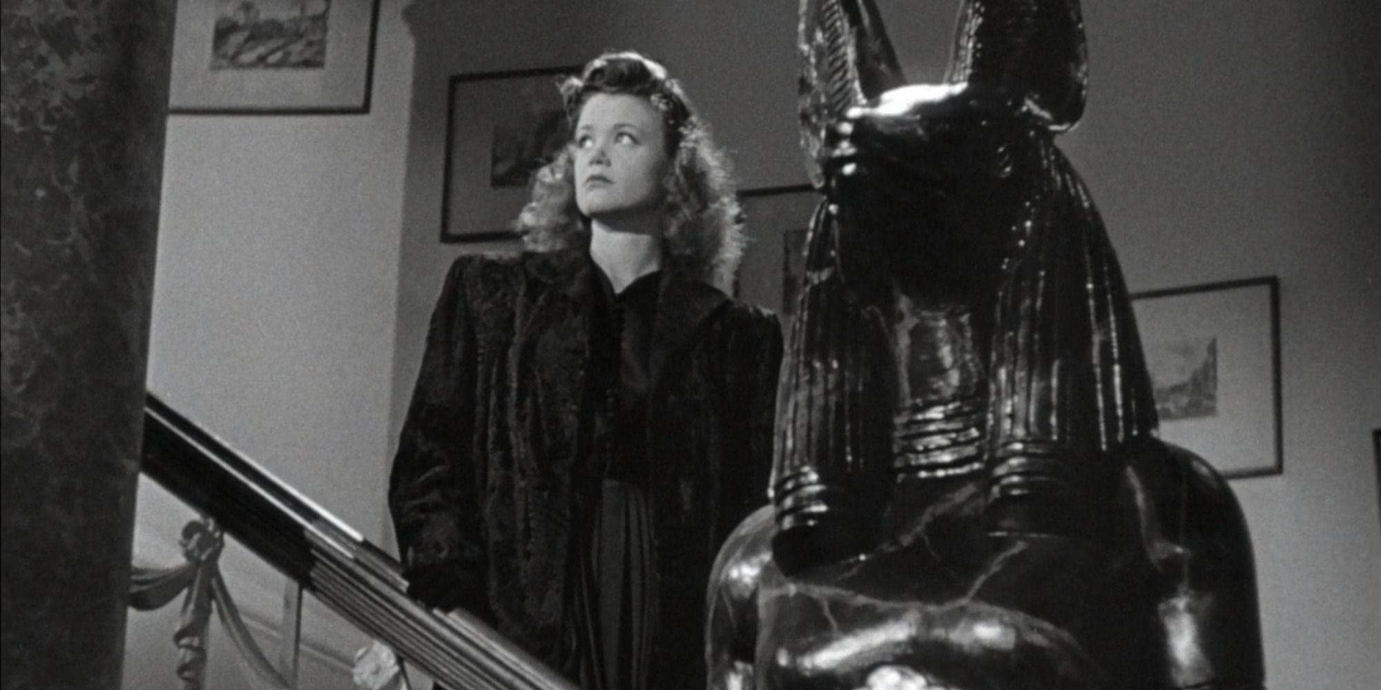 Irena standing by a statue in Cat People 1942