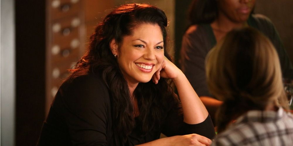 An image of Callie smiling at Meredith as the two sit at Joes Bar in Greys Anatomy