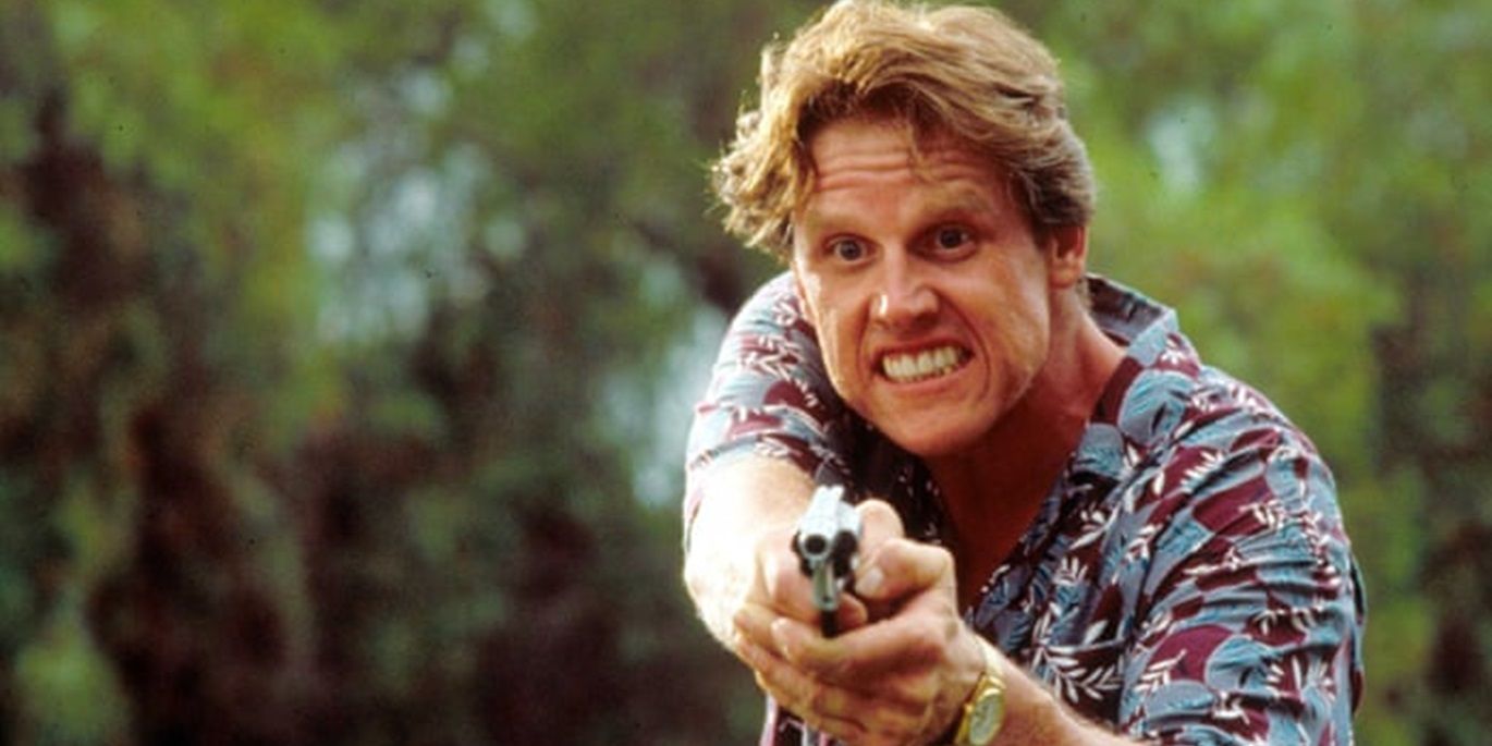 Gary Busey holding a gun in Point Break