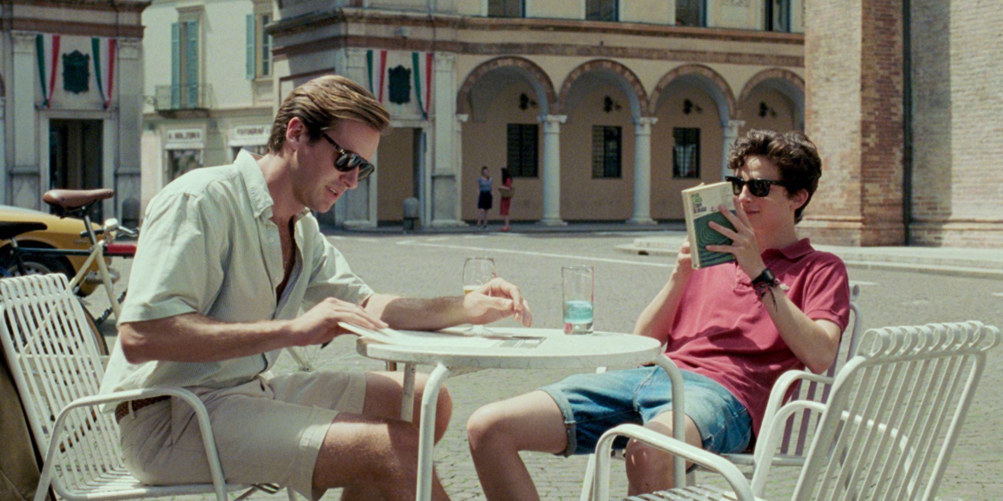 Timoth e Chalamet and Armie Hammer in Call Me by Your Name sitting on a table together with drinks