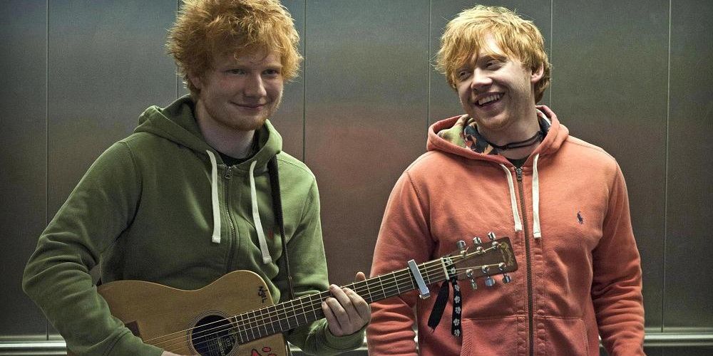 Rupert Grint smiling at Ed Sheeran holding a guitar in Lego Houses music video Cropped