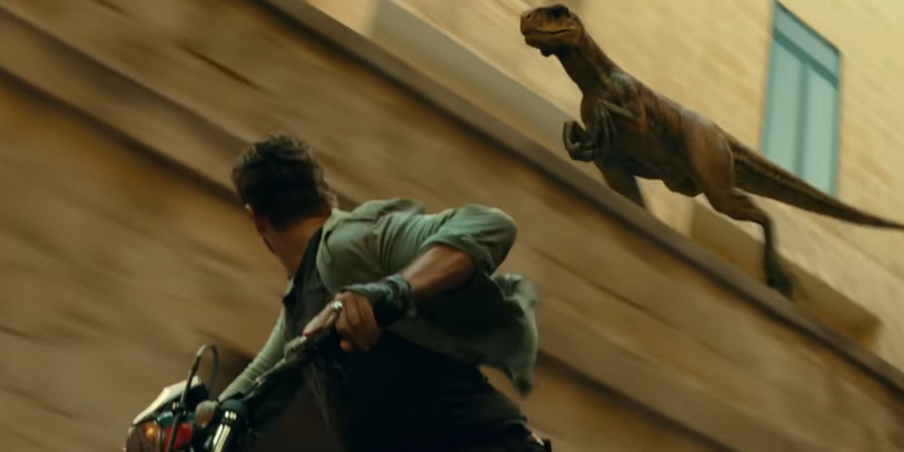 Atrociraptor chasing Owen Grady through a city in Jurassic World Dominion