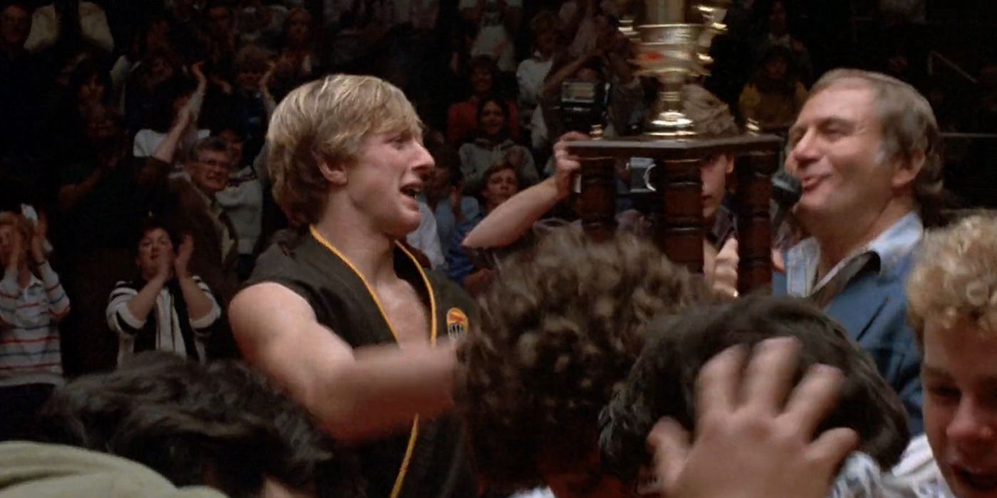 Johnny Lawrence handing the trophy to Daniel LaRusso