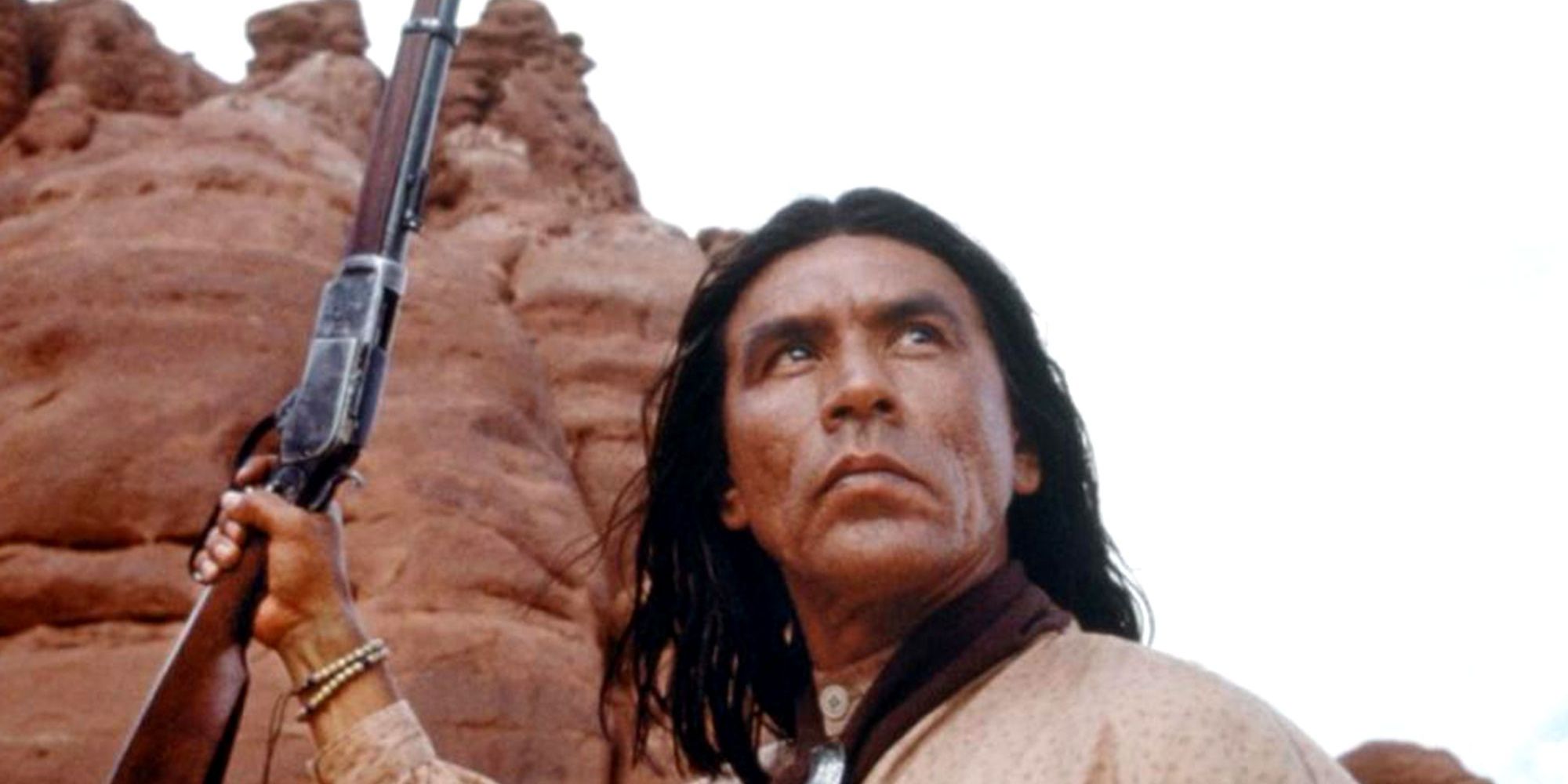 Wes Studi holding a gun and looking up in Geronimo An American Legend Cropped