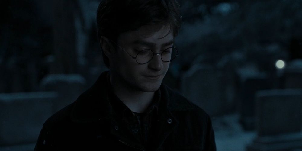 Harry Potter looking down sad in a graveyard in Deathly Hallows Part 1 Cropped 1